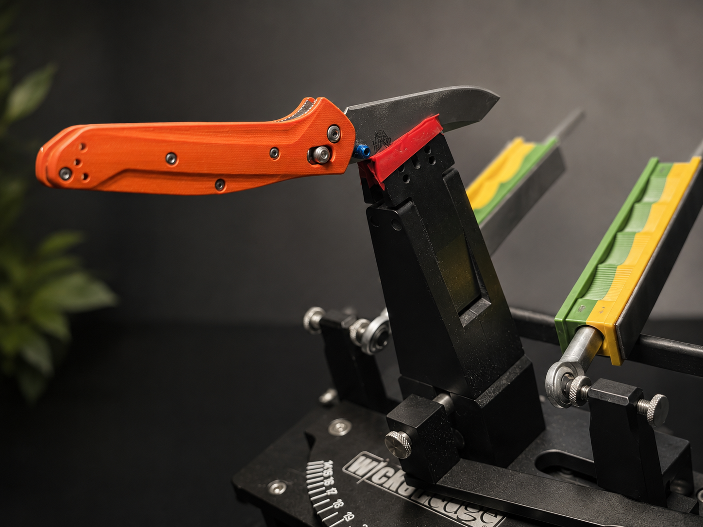 Orange handled knife clamped in sharpening system